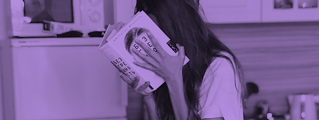 Kvinna läser bok i köket
